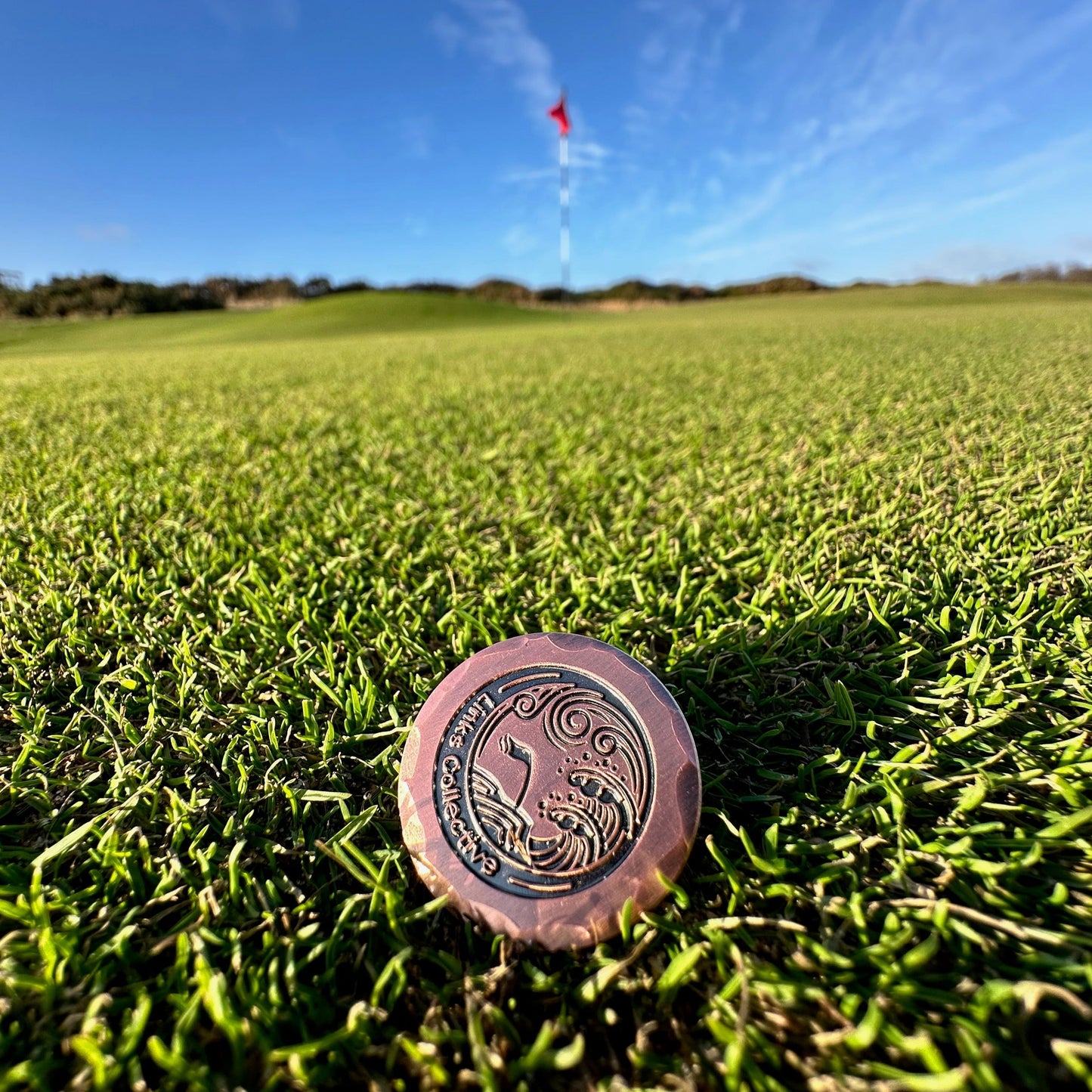 Links collective golf gear on sunny green golf course, flag in background